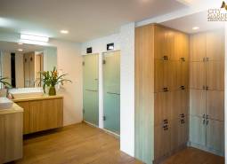 A bathroom with wooden furniture and a sink as part of apartment construction.