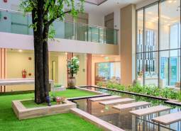 Interior with a spacious garden, lawn, and water features in the construction of apartments.