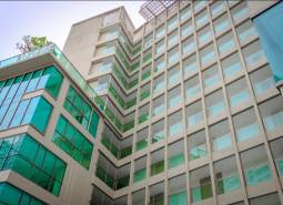 Construction of apartments in Pattaya with a glass facade and balconies in a modern design.