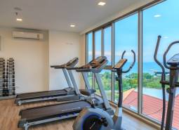 A gym with treadmills and dumbbells, sea view. Apartment construction.