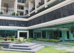 Apartment construction in Pattaya with glass facades and balconies with plants.