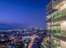 Night panorama of Pattaya with city lights and apartment construction in the foreground.