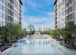 The construction of apartments in Pattaya includes a pool and gardens between the buildings.