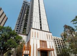 Apartment construction in Pattaya, a high-rise building with modern architecture and greenery around.