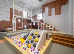 A play corner with balls and a slide in the premises of apartment construction.