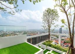 Rooftop terrace with a view of the city of Pattaya and residential buildings.
