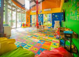 A colorful indoor playground under construction in an apartment building with toys and tables.