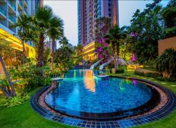 A pool with greenery during the construction of apartments in Pattaya.