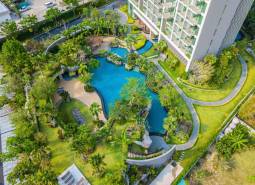 Luxury pool in the middle of a green oasis during the construction of apartments in Pattaya.