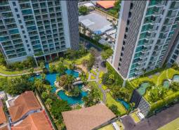 Construction of apartments in the city of Pattaya, with landscaped gardens and swimming pools near residential buildings.