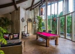 Interior with a billiard table, comfortable seating, and large windows, Apartment construction.