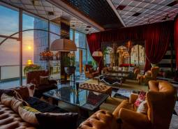 Luxury living room interior with leather furniture and a sunset view.
