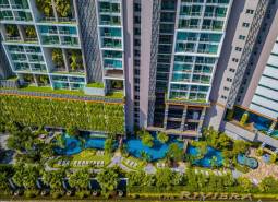 Apartment construction in Pattaya with panoramic views of pools and greenery.