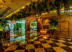 Luxurious interior with a chandelier, green decorations, and patterned flooring. Apartment construction.