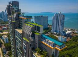 Apartment construction in Pattaya with a rooftop pool and panoramic views of the coastline.