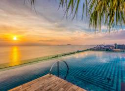 Apartment construction in Pattaya at sunset with a view of the infinity pool.