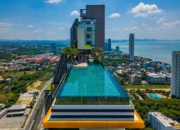 Apartment construction in Pattaya with a rooftop pool and sea view.