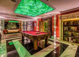 Luxury interior with a billiard table, green elements, and decorations within the construction of apartments.