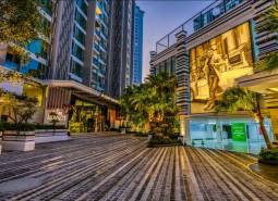 Night architecture during apartment construction in Pattaya with illuminated street and vegetation.