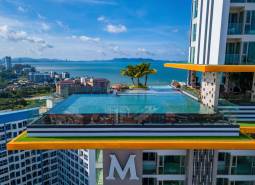 Apartment construction in Pattaya with a rooftop pool and sea view.