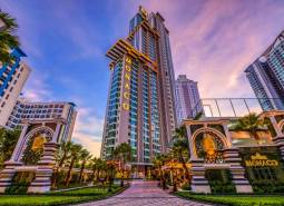 The Monaco skyscraper in the center of residential development in the city of Pattaya, surrounded by palm trees.