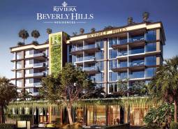 Apartment construction in Pattaya surrounded by greenery and palm trees, modern architectural design.