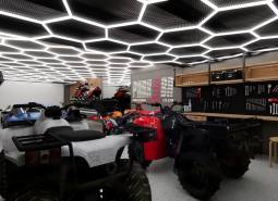 Interior of a commercial space with stored vehicles and tools, futuristic ceiling light decoration.