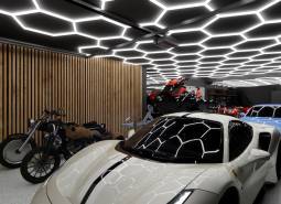 Showrooms with cars, motorcycles, and unique ceiling lighting in the garage.