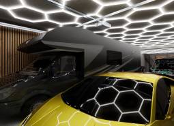 Curtain rods in a commercial space with a light ceiling, a caravan, and a yellow sports car.