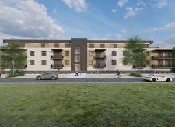 Construction of apartments in Kriváň with cars and pedestrians, surrounded by greenery.