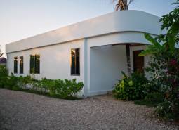 Construction of houses in Paje, Unguja South Region, with greenery around the white structure.