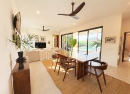 Interior with a dining table, wood-patterned flooring, and large glass doors, Home construction.