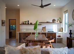 Interior of a kitchen with a wooden dining table, chairs, and shelves in the area of Home Construction.