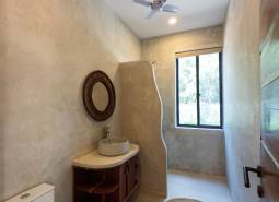 Bathroom with a sink, round rug, and fan. House construction.