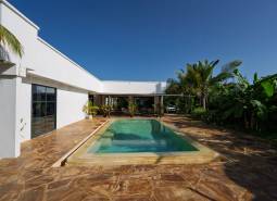 White architecture with a pool amidst greenery in Paje, Unguja South Region.