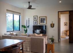 Interior with a sofa, television, and wooden furniture under construction of houses.