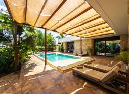 The garden of a family house on Paje Street in Unguja South Region with a swimming pool and sunbeds.