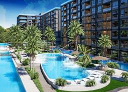 Apartment construction in Pattaya with pools, palm trees, and modern architecture in a tropical setting.