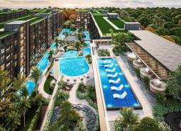 Apartment construction in Pattaya with pools, green roofs, and abundant vegetation.