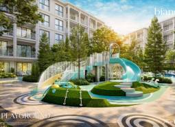 A children's playground at a residential development in Phuket with a large slide and greenery.