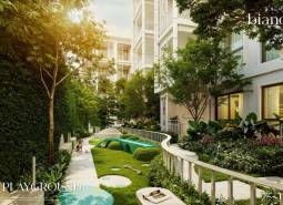The exterior of a residential development in Phuket with a children's playground surrounded by greenery.