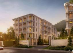 Apartment construction in Phuket, an elegant building surrounded by greenery at dusk.