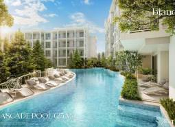 A pool with loungers surrounded by buildings under construction of apartments in Phuket.