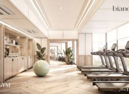 Interior of a gym with wood-patterned flooring and modern fitness equipment. Apartment construction.