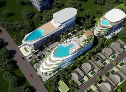 Visualization of apartment construction in Phuket: multi-story buildings with pools surrounded by greenery and a road.