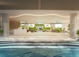 Interior of residential development with a reception and relaxation area, decorated with greenery and seating.