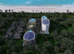 Beachfront apartment development in Phuket with modern buildings and pools surrounded by palm trees.