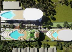 Aerial view of apartment construction in Phuket with rooftop pools and greenery.