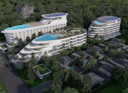 Apartment construction in Phuket with a wavy design and rooftop pools set in greenery.