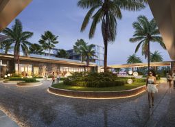 Outside the apartment construction in Phuket, palm trees and illuminated pathways can be seen.